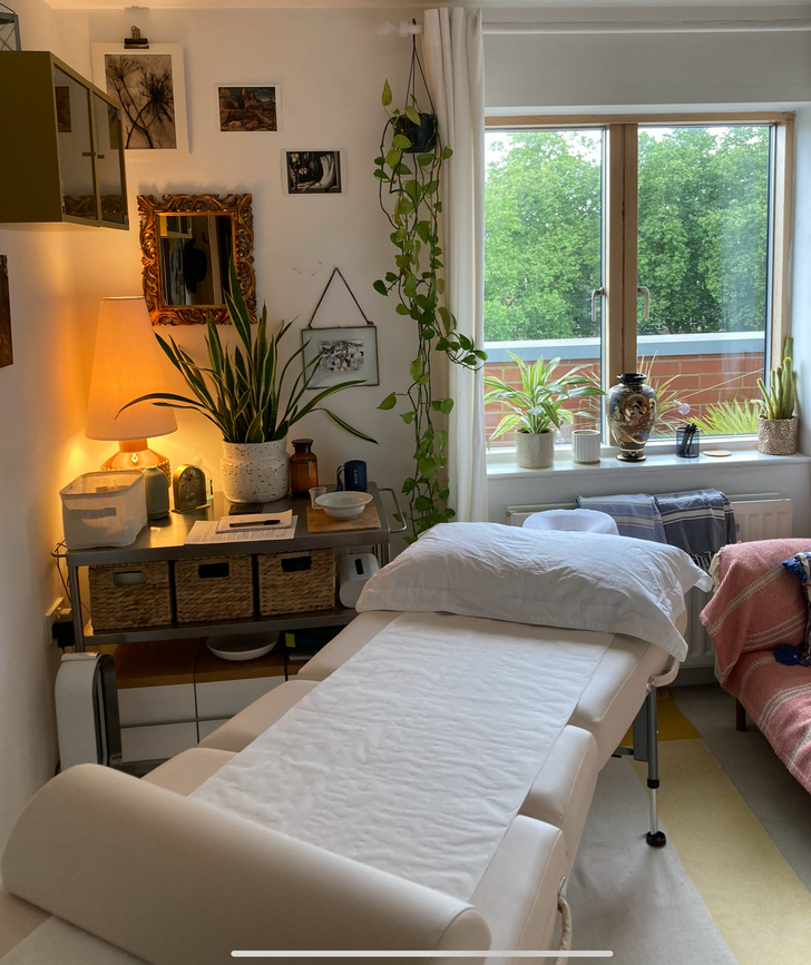 Maria Pelton Massage treatment room in Angel, Islington, London N1, with a massage table, plants and warm lighting.